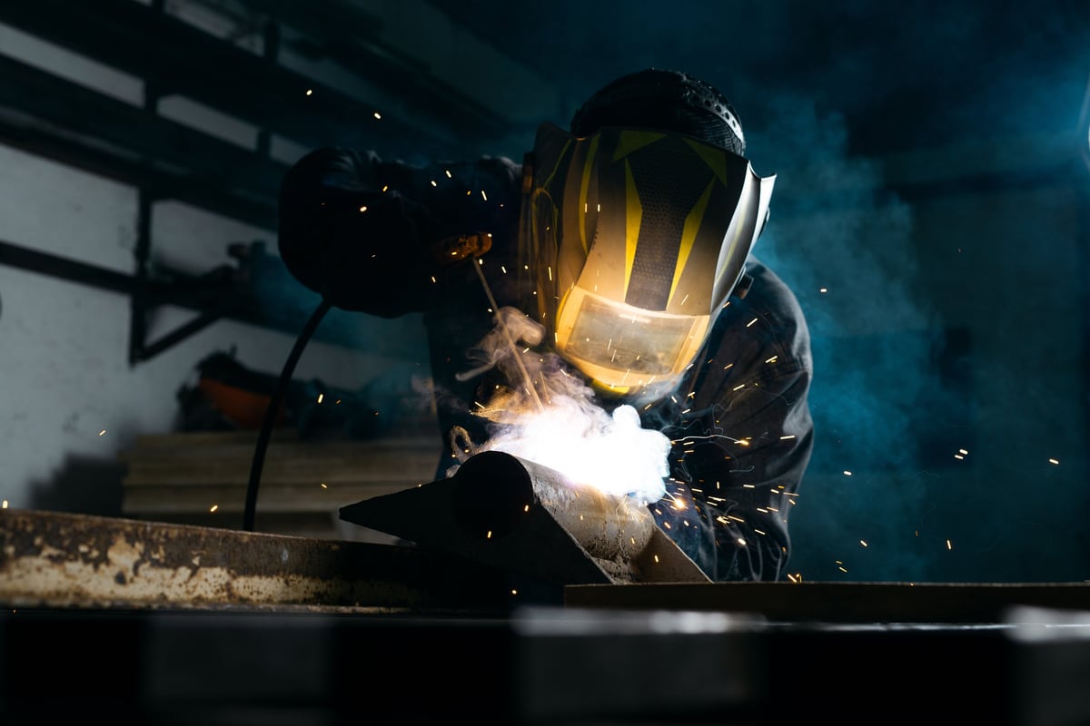Professional welder welding on workbench